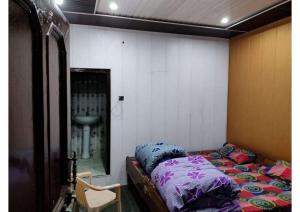 a bedroom with a bed and a sink in it at Hotel Prakriti in Gangotri