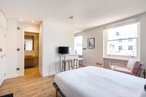 sypialnia z łóżkiem, stołem i krzesłami w obiekcie Brand new studio flat in the heart of Notting Hill w Londynie