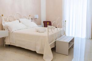 um quarto branco com uma cama branca e uma colcha branca em A casa dei miei em San Pietro Vernotico