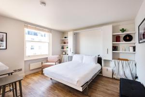 a bedroom with a bed and a desk and a chair at Brand new studio flat in the heart of Notting Hill in London