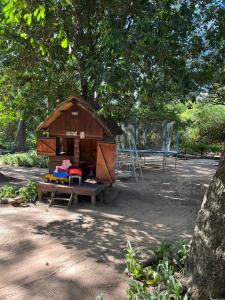 a smallshed sitting under a tree in a park at casa-quinta cerca de corrientes y santa ana in Corrientes