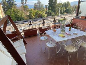 Un patio con una mesa y sillas en un balcón. en Angiolina, en Baveno
