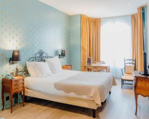 um quarto com uma cama e uma parede azul em Hotel Le Grimaldi by Happyculture em Nice