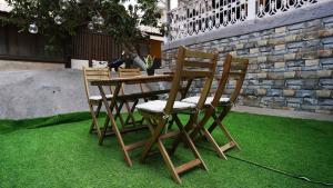 GoSolo Stays في مومباي: طاولة وكراسي خشبية على عشب أخضر