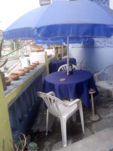 una mesa con sombrilla azul y una mesa con sillas en Hotel tanta Wasi, en Quito
