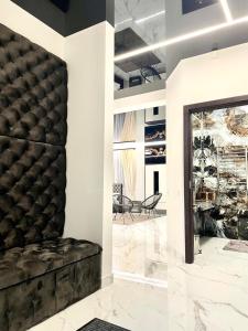 GRAND APARTMENT BALTEZERS في ريغا: غرفة معيشة مع أريكة سوداء ومرآة