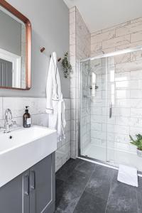 a white bathroom with a sink and a shower at Luxury Crescent View Apartment in Scarborough