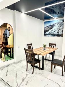 GRAND APARTMENT BALTEZERS في ريغا: غرفة طعام مع طاولة وكراسي خشبية