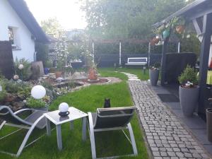 un patio trasero con un gato sentado en la hierba en Ferienwohnung Am Rehwinkel en Fuldatal