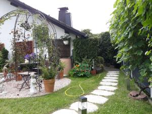 un jardín con un cenador y un sendero en Ferienwohnung Am Rehwinkel en Fuldatal