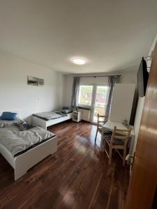 Schlafzimmer mit einem Bett, einem Schreibtisch und einem Tisch in der Unterkunft Gästezimmer - Elbert in Hösbach