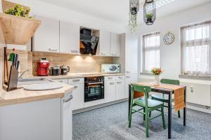 a kitchen with white cabinets and a table and chairs at Pressehaus Apartment Steinweg in Mühlhausen