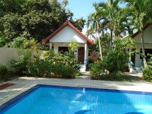 a house with a swimming pool in front of a house at Baan Coconut in Bang Tao Beach
