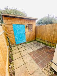 ein Haus mit einer blauen Tür und einem Zaun in der Unterkunft Cosy Cottage in Central Reading Free Parking & Fast Wifi in Reading