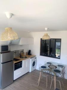 kuchnia ze stołem i kuchenką górny piekarnik w obiekcie A 10min d'Hossegor, T2 avec jardinet et terrasse w mieście Tosse +7 zdjęć