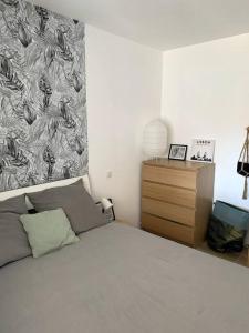 sypialnia z łóżkiem i komodą ze ścianą w obiekcie A 10min d'Hossegor, T2 avec jardinet et terrasse w mieście Tosse