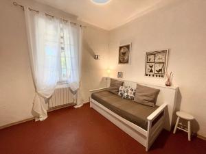 a small bedroom with a bed and a window at Le Mas, maison au charme provençale idéalement située entre mer et vignes in Hyères