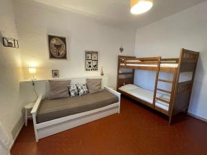 a bedroom with two bunk beds and a ladder at Le Mas, maison au charme provençale idéalement située entre mer et vignes in Hyères