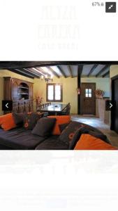sala de estar con sofá y almohadas de color naranja en Casa rural altza erreka en Errazu