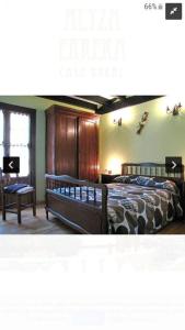 Un dormitorio con 2 camas y un banco en una habitación en Casa rural altza erreka en Errazu