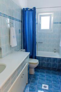 uma casa de banho em azulejos azuis com um WC e um lavatório em AEGEA MILOS em Adamas