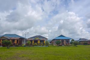 una fila de casas en un campo bajo un cielo nublado en OYO 92225 Filadelfia Resto & Penginapan, en Manado