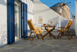 patio z 2 krzesłami i stołem w obiekcie AEGEA MILOS w mieście Adamas