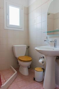 uma casa de banho com um WC e um lavatório em AEGEA MILOS em Adamas