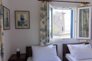 a bedroom with a bed and a window with curtains at AEGEA MILOS in Adamas
