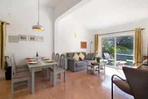 een woonkamer met een tafel en een bank bij Casa Arcadia T3 in São Bartolomeu de Messines