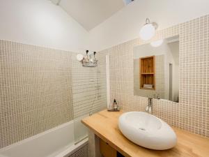La salle de bains est pourvue d'un lavabo blanc et d'un miroir. dans l'établissement Le Clos des Aubrys, à Châteauroux