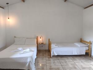 two beds sitting next to each other in a room at Lago 7 Cores in Tapiraí