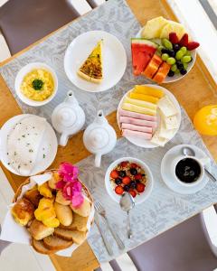 a table topped with plates of food and fruit at Le Village Boutique Hotel in Búzios