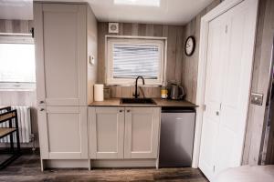 een keuken met witte kasten en een wastafel bij Wansbeck Riverside Caravan Park in Ashington