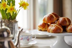 a plate of pastries on a table with a cup of coffee at Coworth Park - Dorchester Collection in Ascot