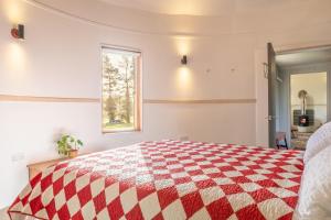 a bedroom with a red and white quilt on a bed at Extraordinarily converted grain stores - The Silos in Ipswich