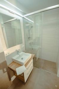 y baño blanco con lavabo y ducha. en Mein Appartement Nr.9 en Planneralm