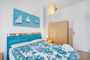 Schlafzimmer mit einem Bett mit einer blauen und weißen Bettdecke in der Unterkunft Casa Cecilia in Marina dʼAndora