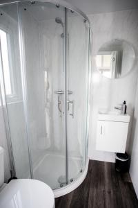 a bathroom with a shower and a toilet and a sink at Wansbeck Riverside Caravan Park in Ashington