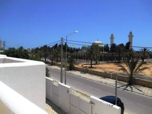 une vue sur une rue avec une mosquée derrière une clôture dans l'établissement Une grande villa meublée, à Monastir