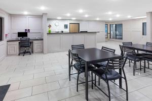 Super 8 by Wyndham League City Kemah Area في ليغ سيتي: مطبخ وغرفة طعام مع طاولات وكراسي