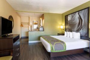 a hotel room with a bed and a flat screen tv at Super 8 by Wyndham NAU/Downtown Conference Center in Flagstaff