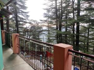 un balcón de una casa con vistas a los árboles en Shree Guest House, en McLeod Ganj