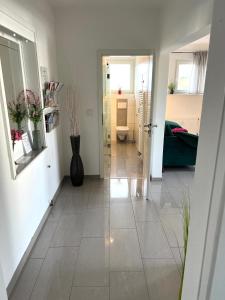 a hallway with a tile floor and a bathroom at Ferien-Whg Möwe nähe Steinhuder Meer in Hagenburg