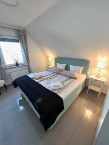 a bedroom with a large bed with two tables and a window at Ferien-Whg Möwe nahe Steinhuder Meer mit Garten und Balkon in Hagenburg