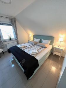 ein Schlafzimmer mit einem großen Bett mit zwei Tischen und einem Fenster in der Unterkunft Ferien-Whg Möwe nähe Steinhuder Meer in Hagenburg