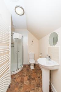 uma casa de banho com um WC, um lavatório e um chuveiro em The Granary with Hot Tub em Forgandenny