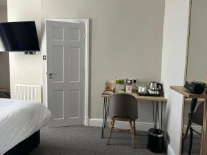 a bedroom with a bed and a desk with a chair at Hotel Penwig in New Quay