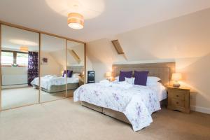 a bedroom with two beds and a large mirror at The Granary with Hot Tub in Forgandenny