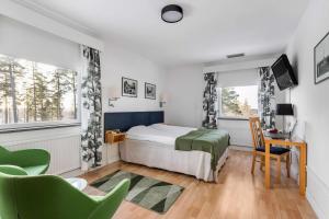 a bedroom with a bed and a desk and two windows at Hotel Malmkoping; Sure Hotel Collection by Best Western in Malmköping